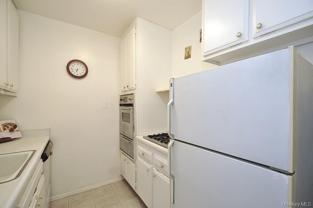 260 Garth Road, Unit 4A5 Scarsdale, NY 10583 - Photo 14 of 35 a white refrigerator freezer and a stove sitting inside of a kitchen