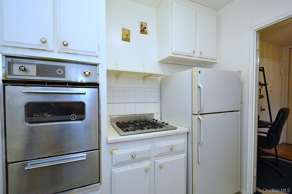 260 Garth Road, Unit 4A5 Scarsdale, NY 10583 - Photo 29 of 35 a kitchen with refrigerator and cabinets