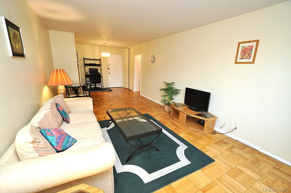 260 Garth Road, Unit 4A5 Scarsdale, NY 10583 - Photo 5 of 35 a living room with a bed furniture and a flat screen tv
