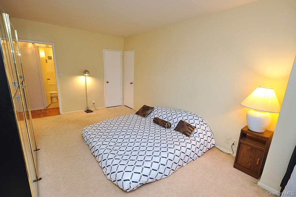 260 Garth Road, Unit 4A5 Scarsdale, NY 10583 - Photo 8 of 35 a bedroom with a bed and wooden floor
