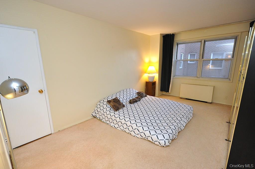 260 Garth Road, Unit 4A5 Scarsdale, NY 10583 - Photo 9 of 35 a bedroom with a bed and wooden floor