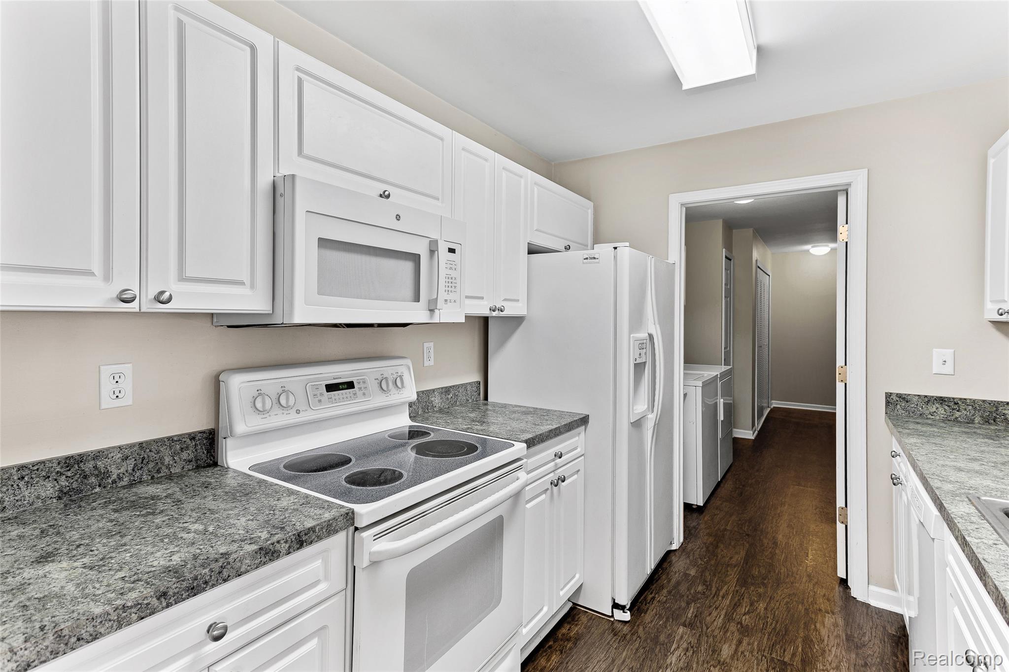 3553 Oakmonte Boulevard Rochester, MI 48306 - Photo 23 of 42 Kitchen featuring white cabinetry with silver-tone hardware, a white electric range with an overhead microwave, and dark speckled countertops
