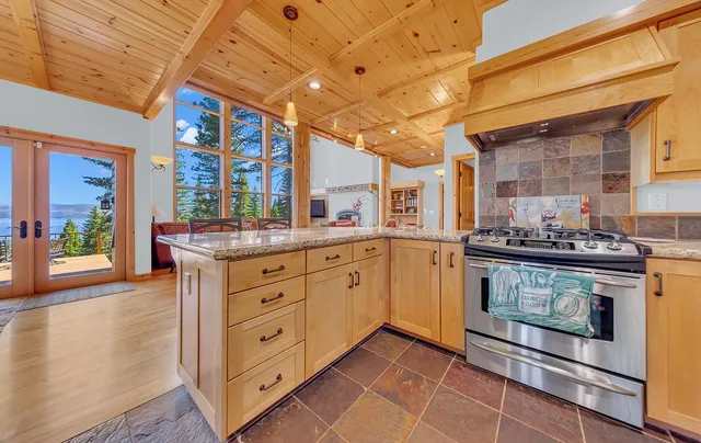 a kitchen with stainless steel appliances granite countertop a stove a sink and a microwave