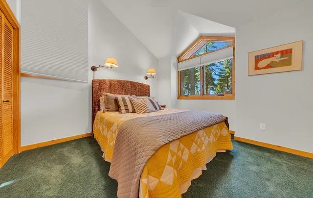 a bedroom with a bed and a painting on the wall