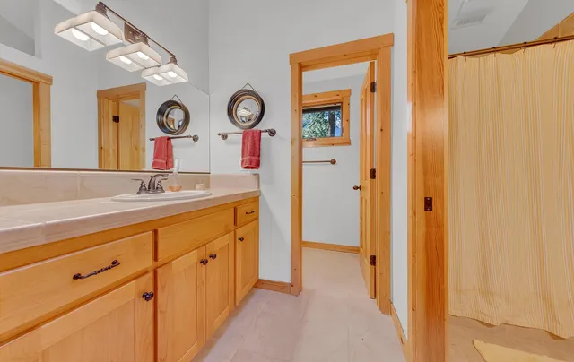 a spacious bathroom with a mirror and a sink