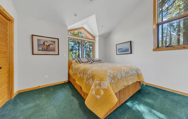 a bed sitting in a spacious bedroom next to a window