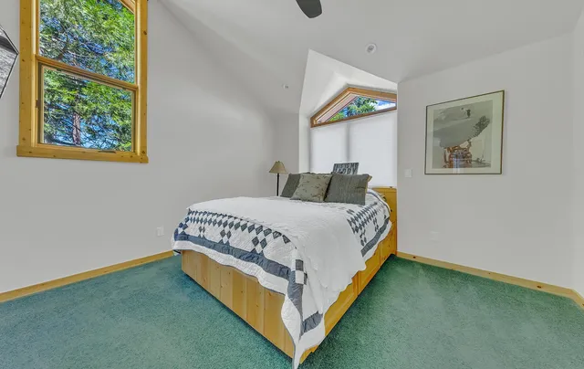 a bedroom with a bed and painting on the wall