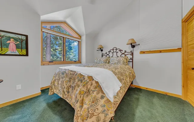 a bed sitting in a bedroom next to a window