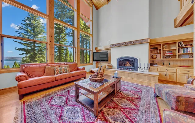 a living room with fireplace furniture and a floor to ceiling window