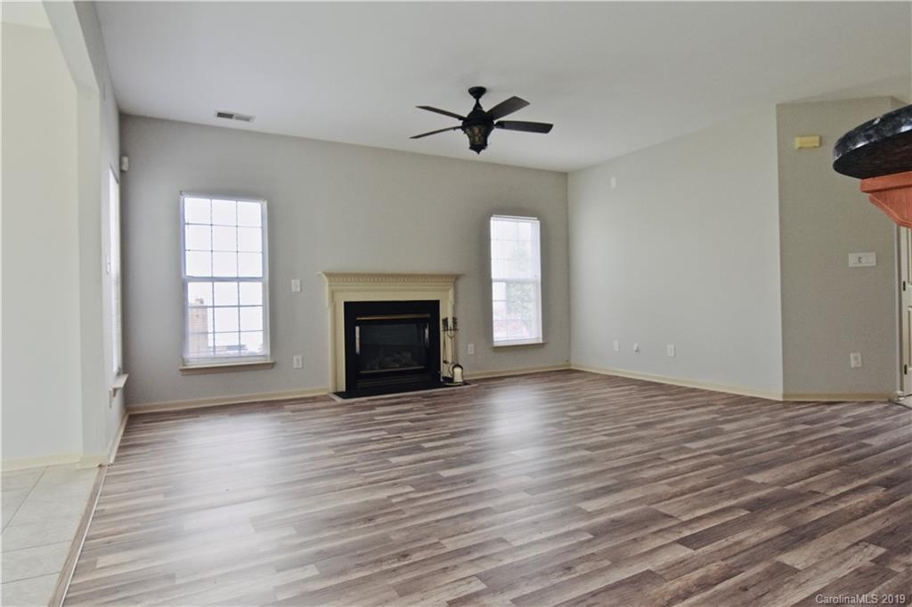509 Circle Trace Road Monroe, NC 28110 - Photo 16 of 36 an empty room with wooden floor fireplace and windows