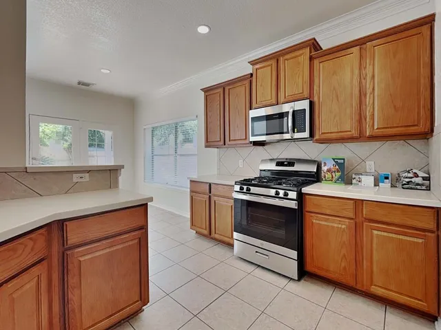 a kitchen with stainless steel appliances granite countertop a stove microwave and sink