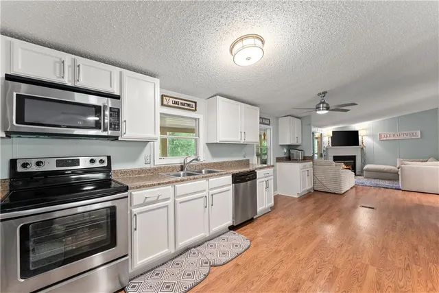 a kitchen with sink a microwave and cabinets