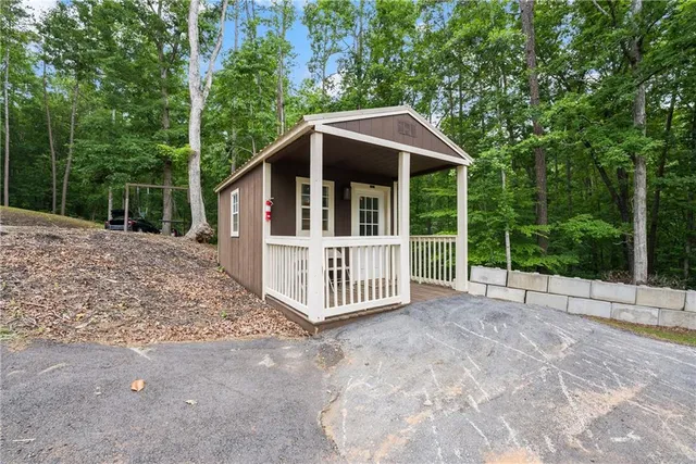 a view of a house with a yard and large trees