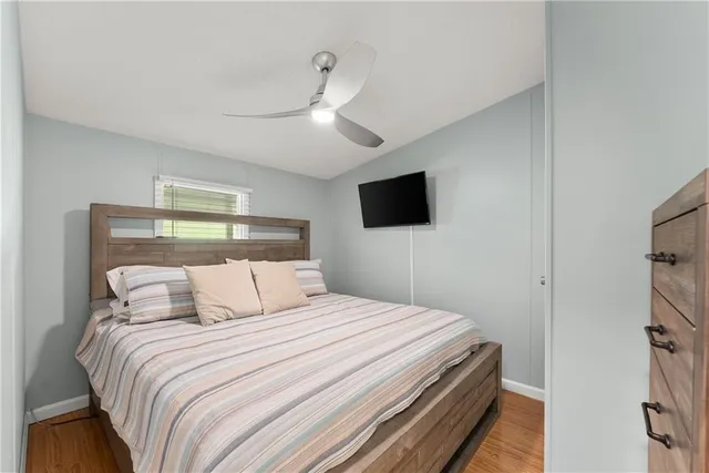 a bedroom with a bed and a flat tv screen on wall
