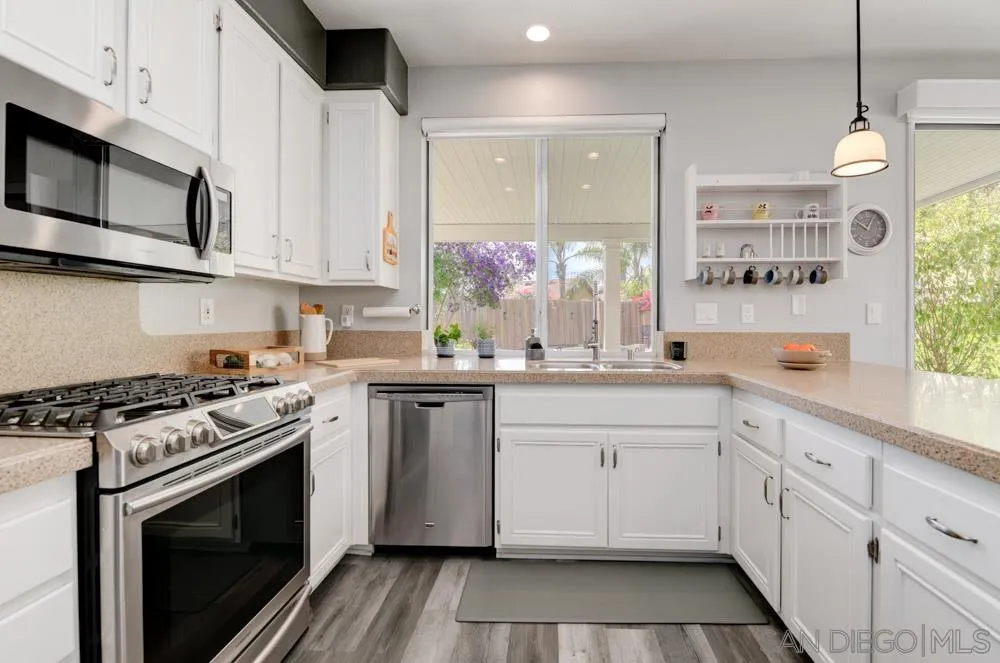 963 Martinique Drive Chula Vista, CA 91913 - Photo 13 of 37 a kitchen with stainless steel appliances granite countertop a stove a sink and a microwave