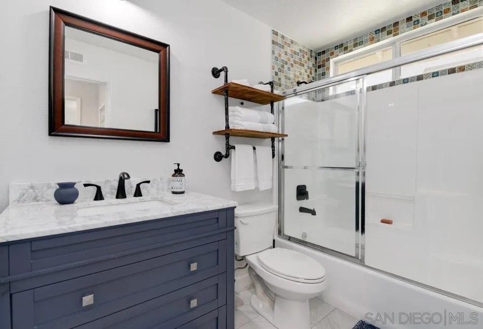 963 Martinique Drive Chula Vista, CA 91913 - Photo 25 of 37 a bathroom with a granite countertop sink toilet a mirror and shower
