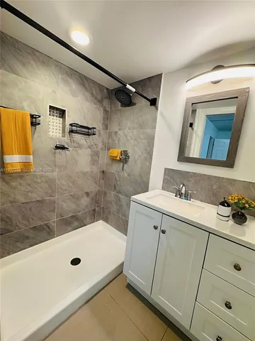 a bathroom with a tub sink and mirror
