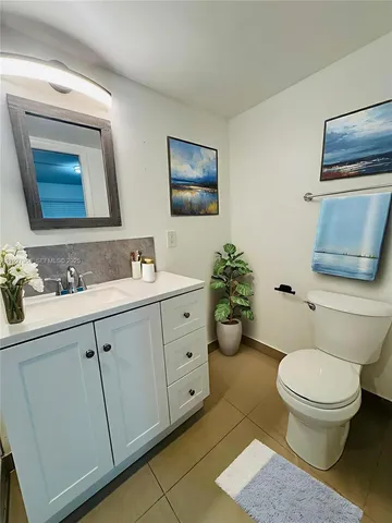 a bathroom with a toilet a sink and mirror