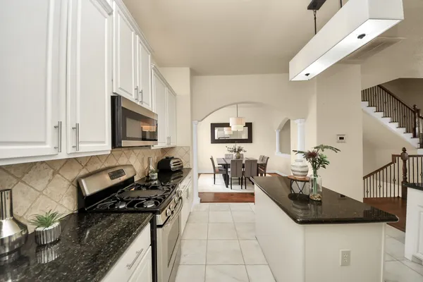 a kitchen with stainless steel appliances granite countertop a sink stove and cabinets