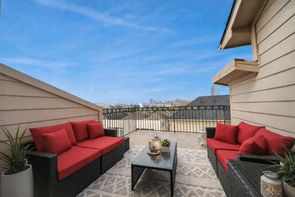 a roof deck with couches and wooden floor