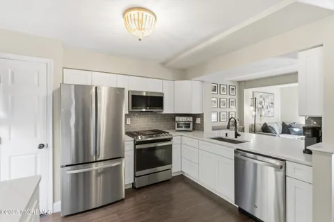 a kitchen with stainless steel appliances a refrigerator sink and microwave
