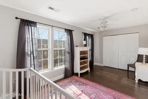 a view of a bedroom with wooden floor and windows