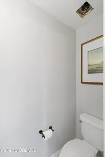 a white toilet sitting next to a white sink and vanity