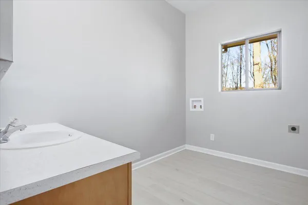 an empty room with wooden floor and window