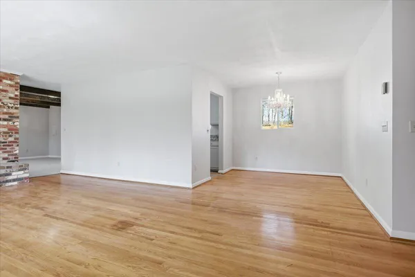 a view of a hallway with wooden floor and entryway