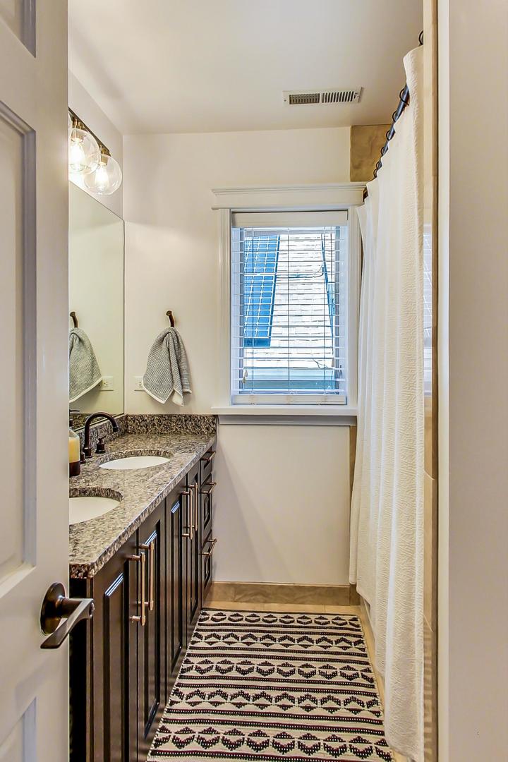 4133 North Kenneth Avenue Chicago, IL 60641 - Photo 32 of 54 a view of a bathroom with sinks and mirror