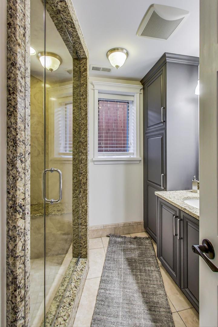 4133 North Kenneth Avenue Chicago, IL 60641 - Photo 42 of 54 a bathroom with a mirror and a shower