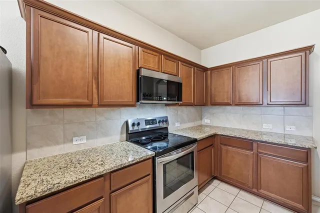 a kitchen with stainless steel appliances granite countertop white cabinets sink and dishwasher