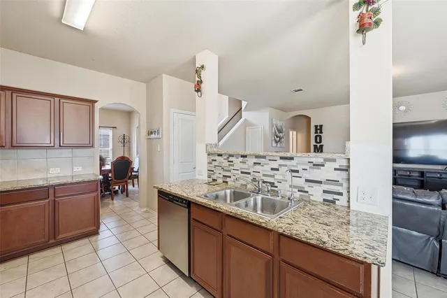 a kitchen with kitchen island granite countertop a sink and cabinets