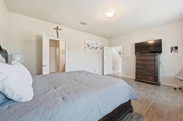 a spacious bedroom with a bed and a flat screen tv