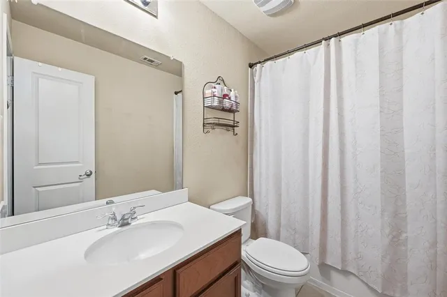 a bathroom with a sink a toilet and shower curtain