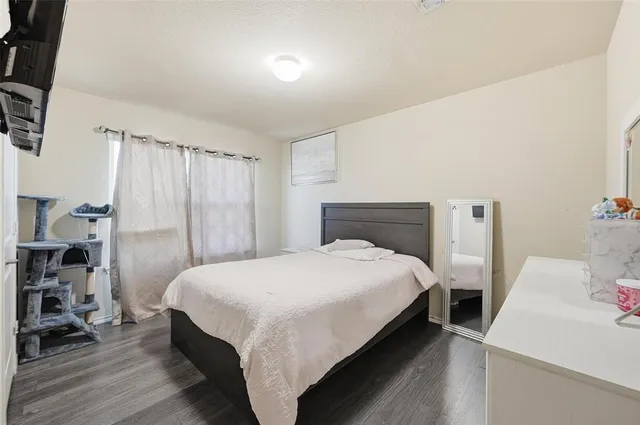 a bedroom with a bed and a wooden floor