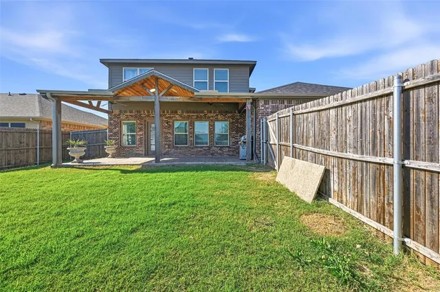 a view of a house with brick walls and a yard with table and chairs