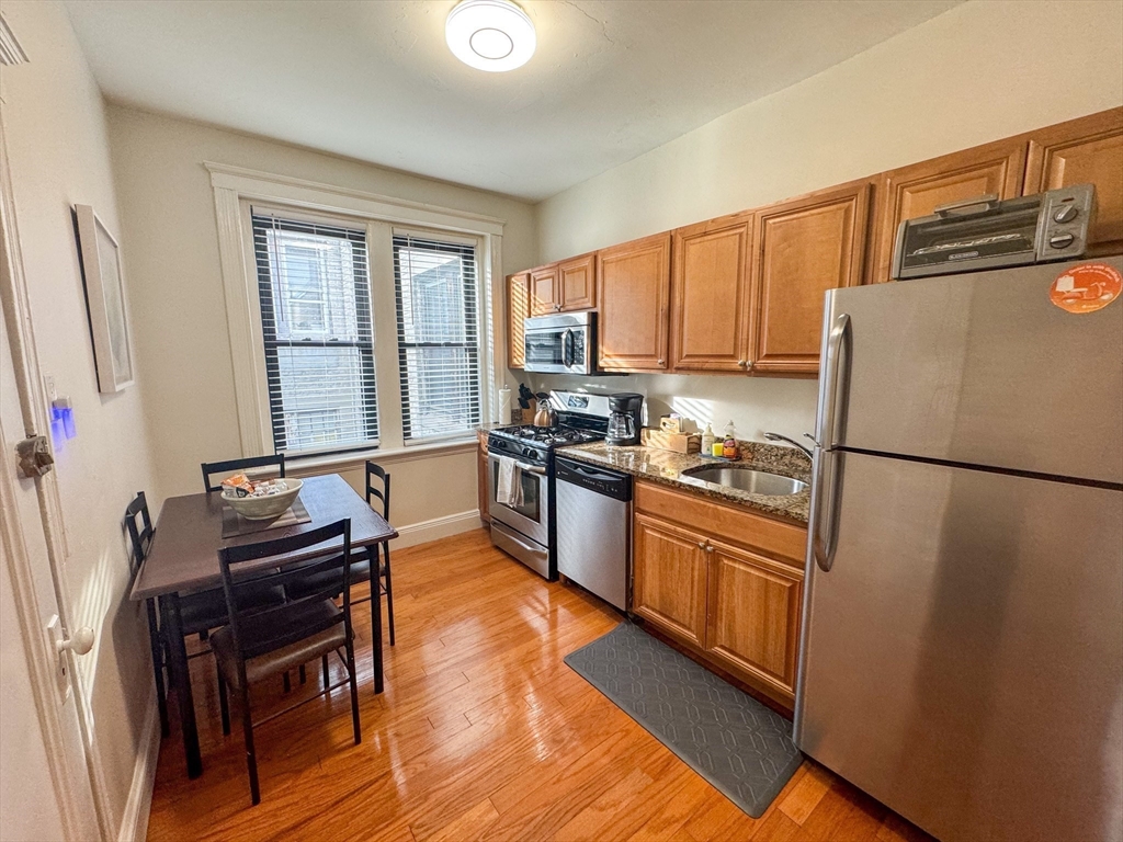 29 Mt Hood Road, Unit 12FURNISHED Boston, MA 02135 - Photo 4 of 11 a kitchen with granite countertop a refrigerator stove top oven and sink