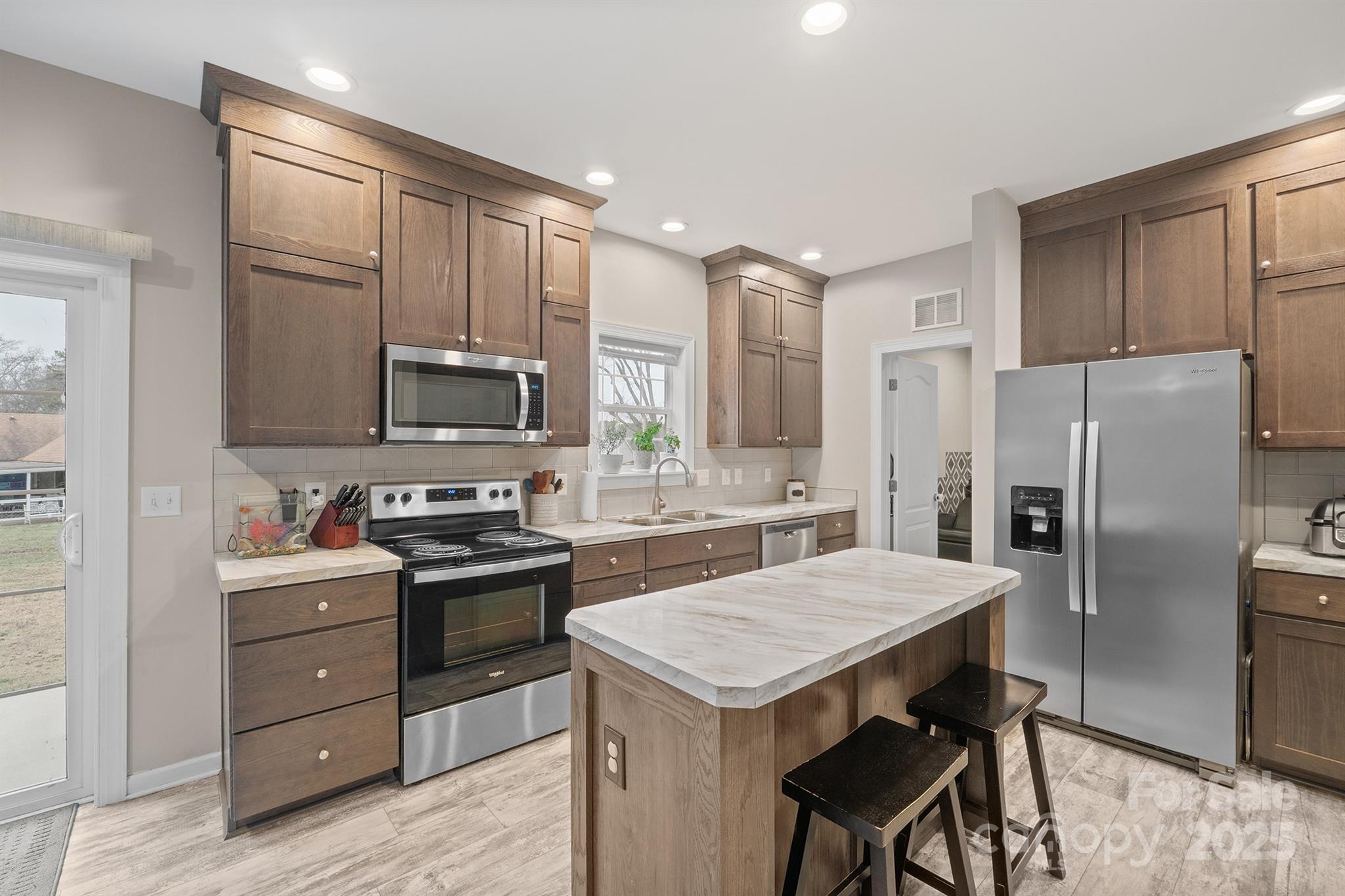 486 Stutts Road Mooresville, NC 28117 - Photo 10 of 35 a kitchen with a refrigerator a stove a sink and a microwave