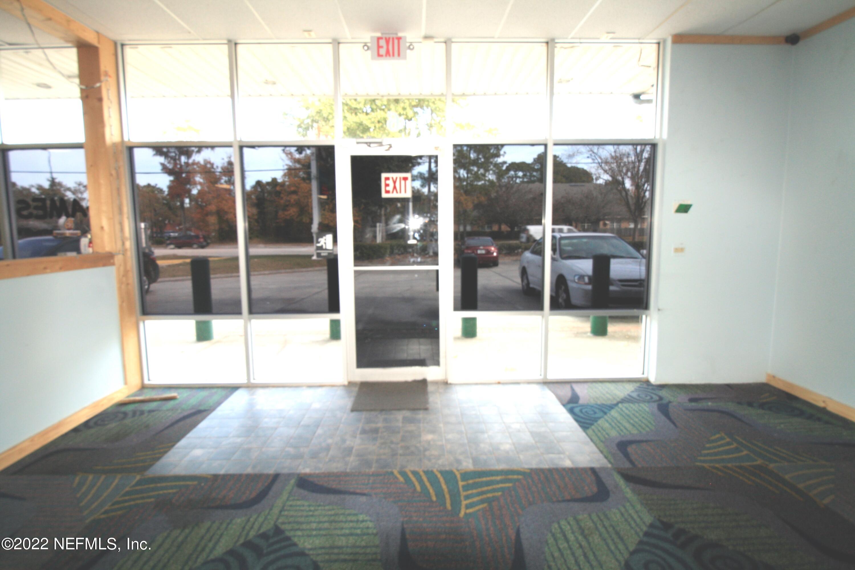9766 Old St Augustine Road, Unit 7 Jacksonville, FL 32257 - Photo 8 of 9 a view of an empty room with wooden floor and a glass door
