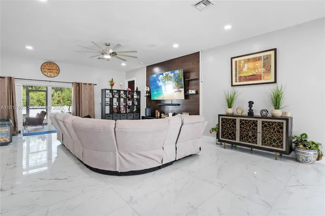 a living room with furniture a chandelier and a flat screen tv