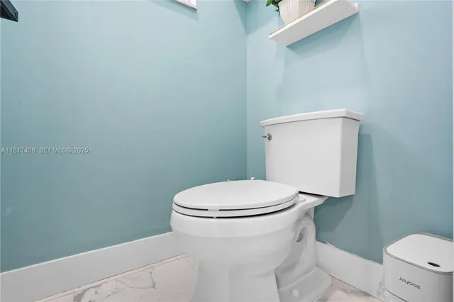 a white toilet sitting next to a white sink and vanity