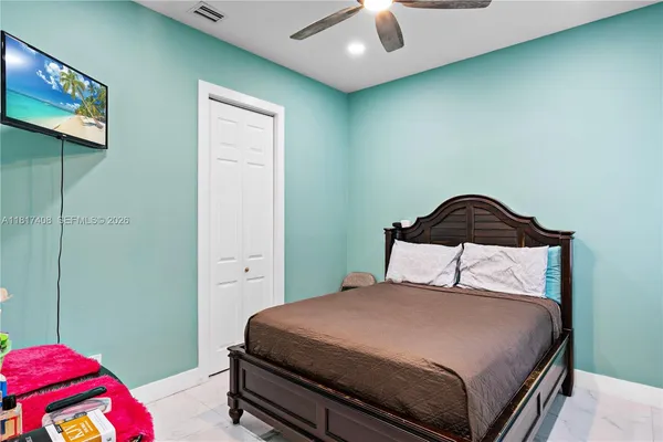 a bedroom with a bed and a ceiling fan