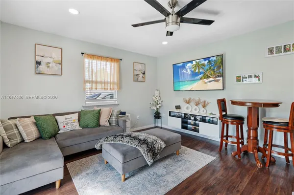 a living room with furniture and a flat screen tv with wooden floor