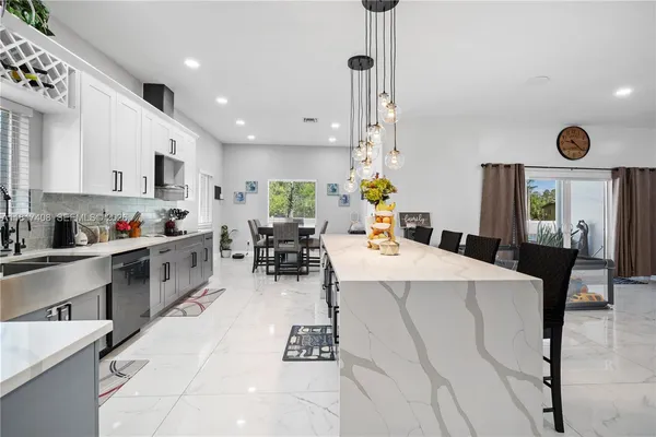 a large kitchen with a table chairs and a refrigerator