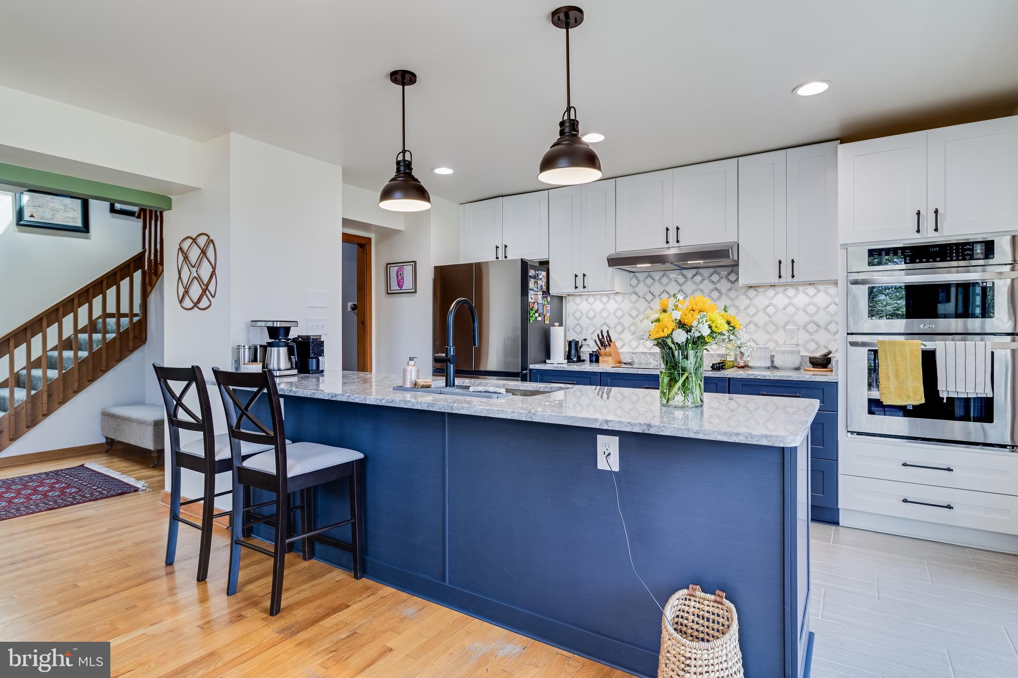 247 Frontier Trail Lusby, MD 20657 - Photo 11 of 62 a kitchen with stainless steel appliances a dining table chairs refrigerator and microwave