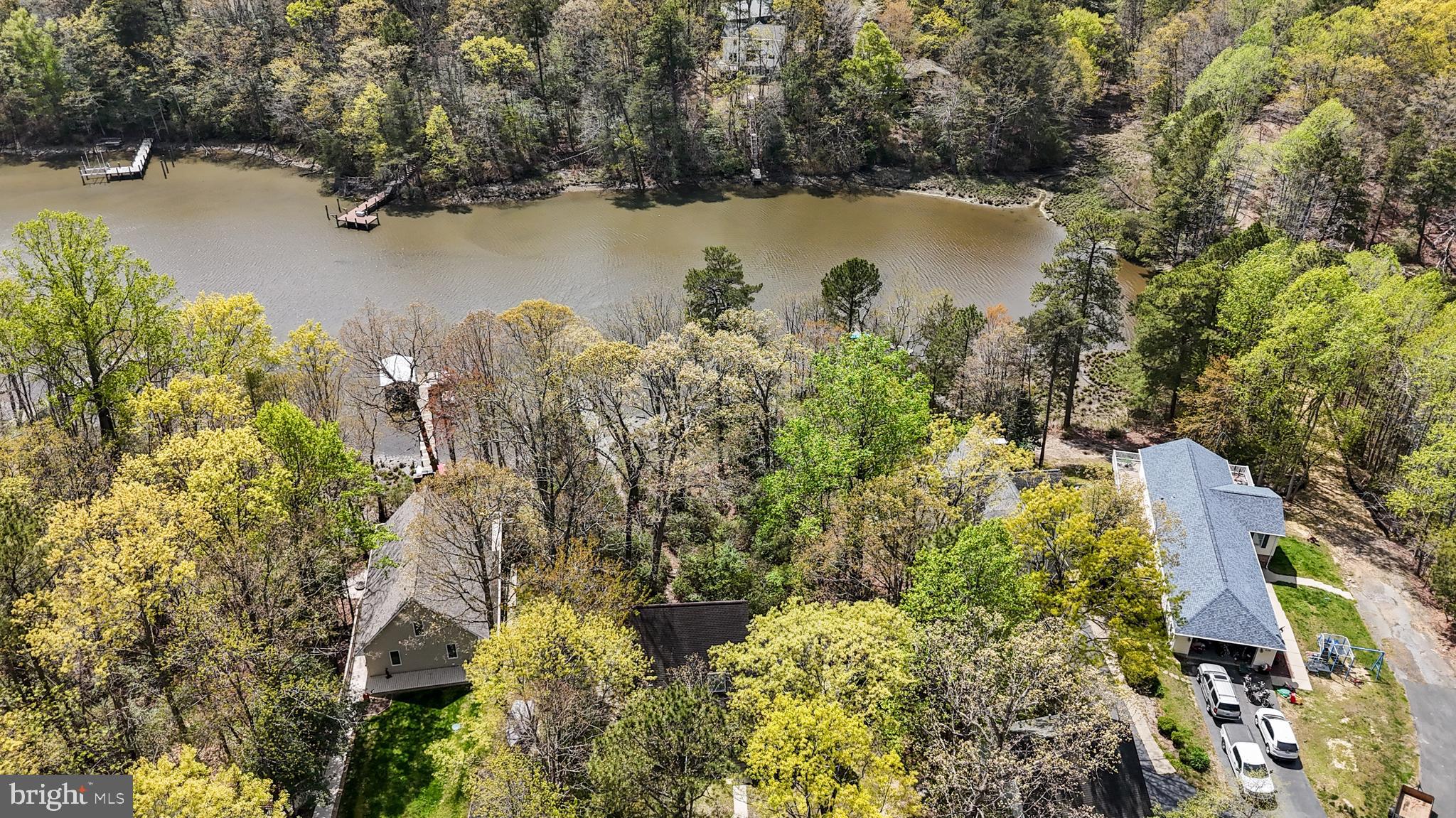 247 Frontier Trail Lusby, MD 20657 - Photo 55 of 62 a view of a lake with a house and a yard with wooden bridge