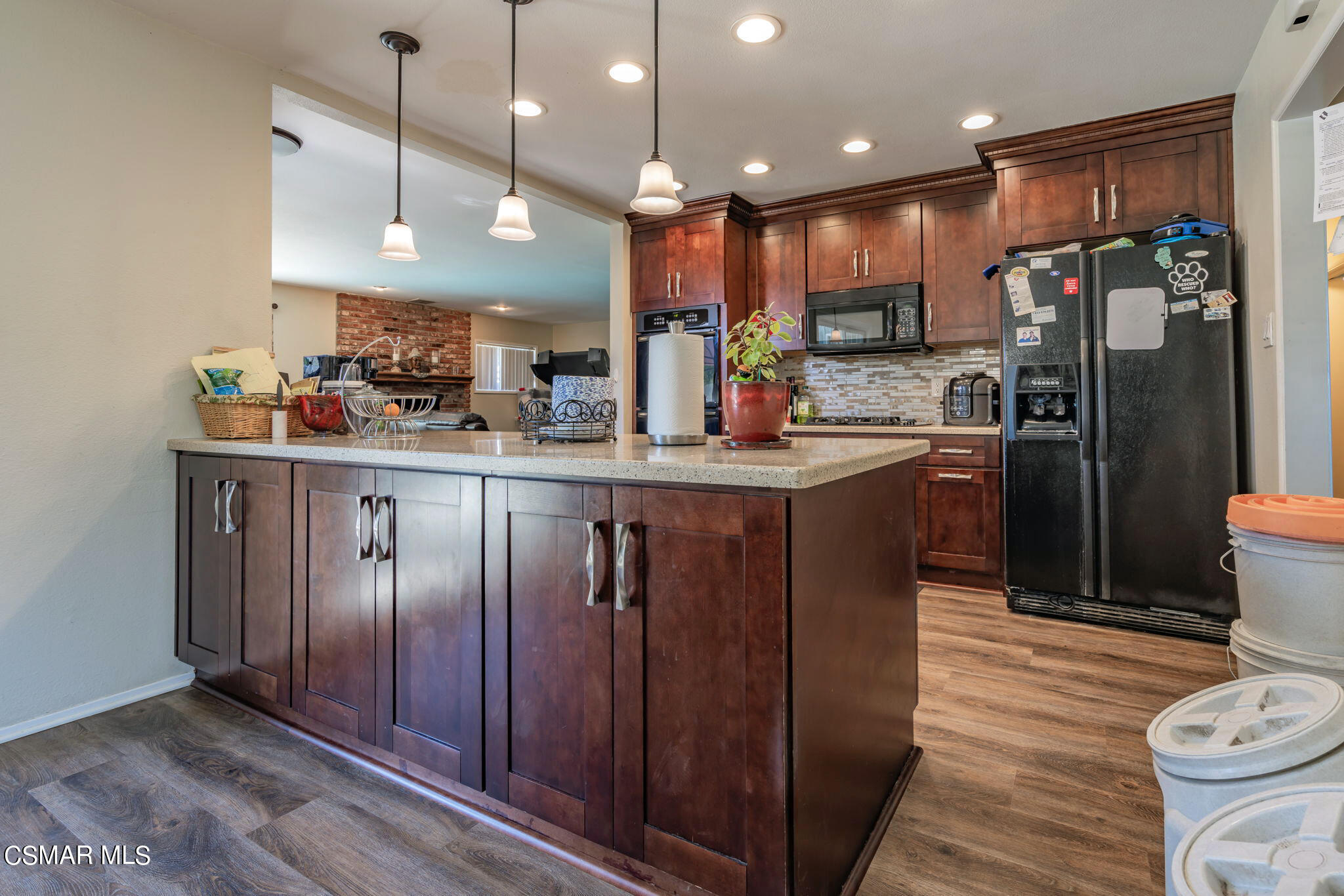 1765 Barnes Street Simi Valley, CA 93063 - Photo 7 of 30 a kitchen with stainless steel appliances granite countertop a refrigerator a sink dishwasher a stove and a dining table with wooden floor