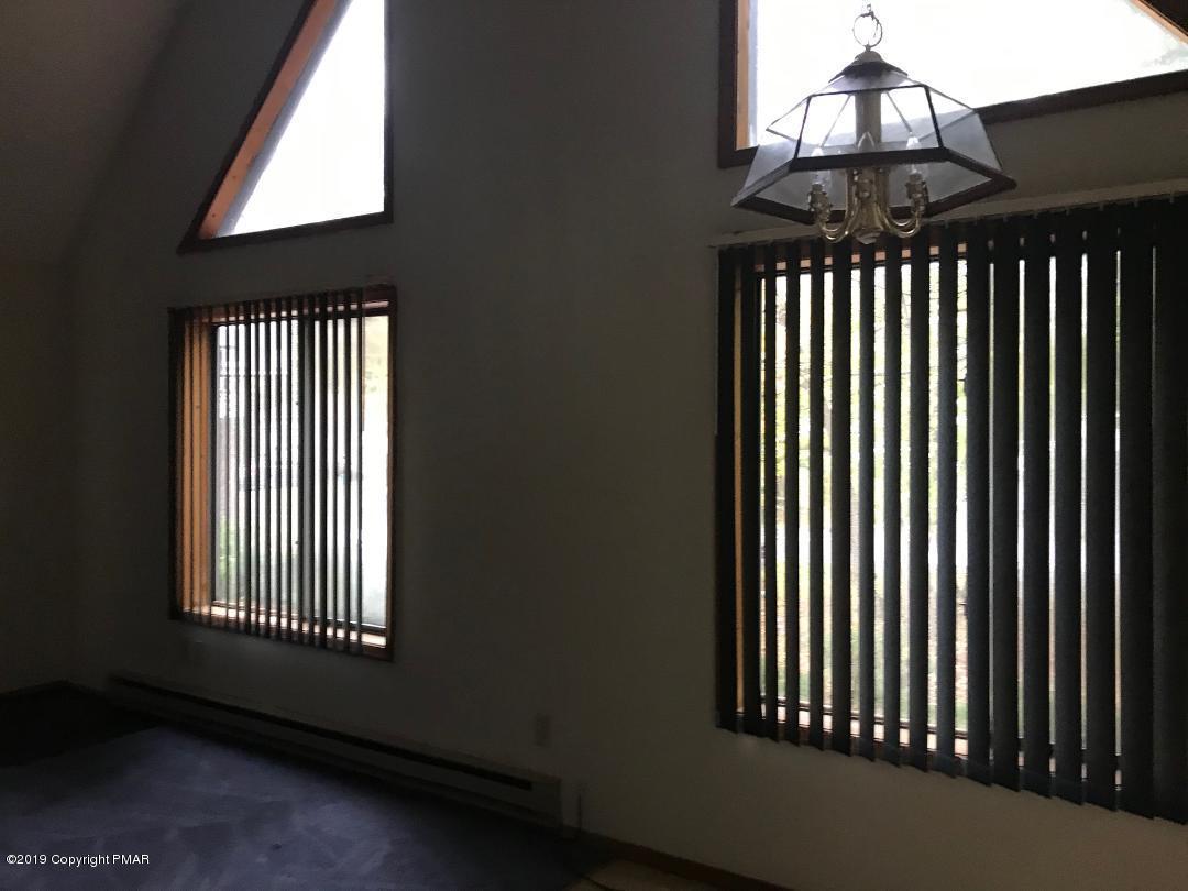 1129 Norfolk Road Tobyhanna, PA 18466 - Photo 5 of 14 an empty room with wooden floor a chandelier fan and windows