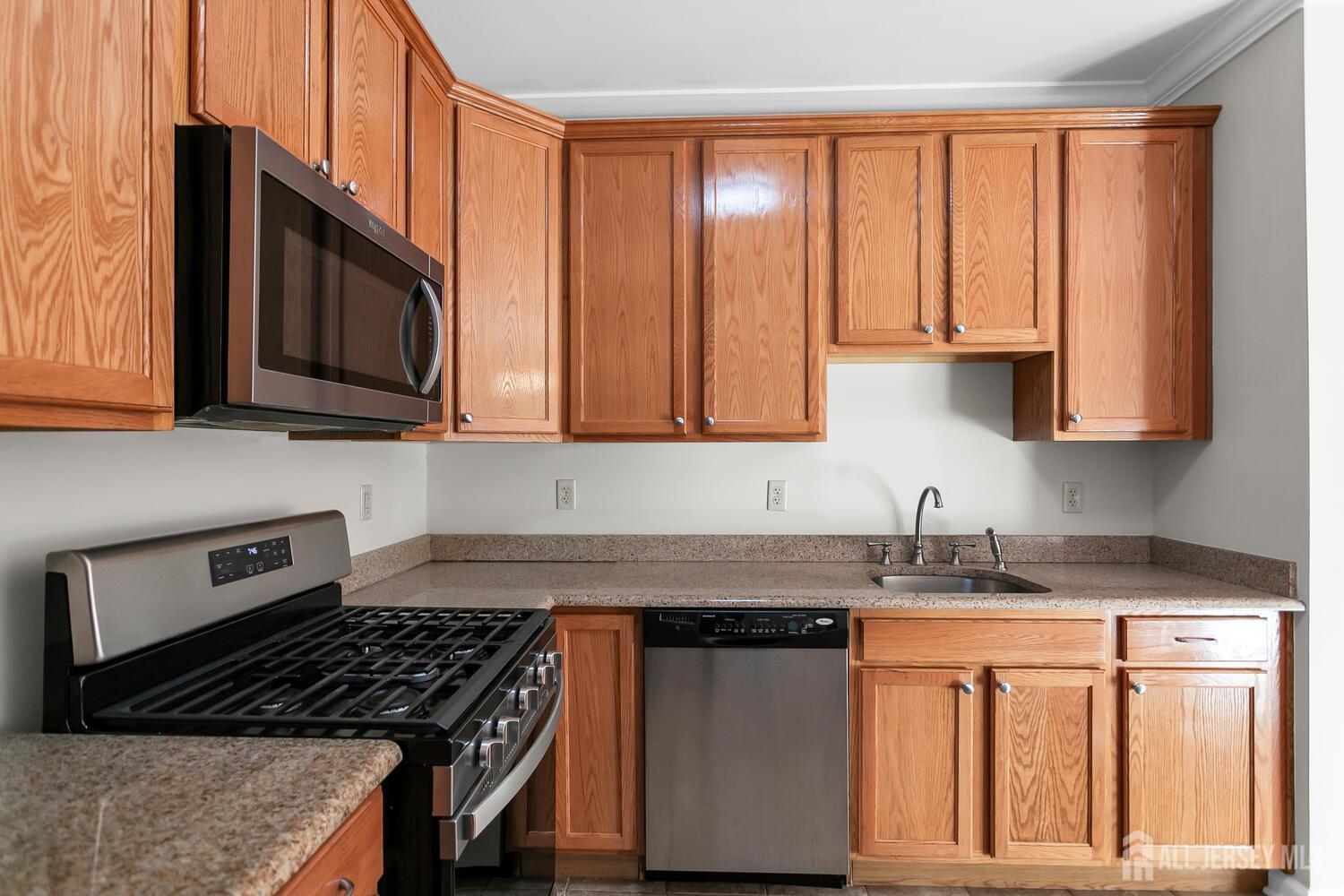 325 Regency Place Woodbridge, NJ 07095 - Photo 17 of 30 a kitchen with stainless steel appliances granite countertop a stove a sink dishwasher and a microwave oven with cabinets